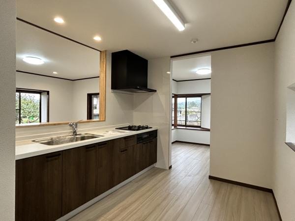 【リフォーム完成・キッチンスペース】キッチンスペースは料理用のスペースのほかキッチン裏に冷蔵庫や食器棚を置いていただけるスパースも確保してリフォーム。対面式ですが、広々としたリビングを生かし、キッチン周りもゆとりある空間となっています。