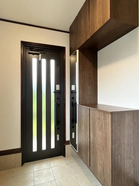 【リフォーム完成・玄関内観】玄関は床のタイル張りや壁・天井のクロス張り、シューズボックスの交換等のリフォームを行いました。土間部分を延長し、趣味のお荷物やベビーカーなどを収納していただけるシューズクロークも新設。