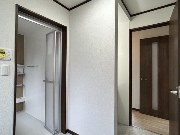 【リフォーム完成・洗面所】洗面所は床のクッションフロア貼り、壁・天井のクロス張替え、照明交換等のリフォームを行いました。洗面台スペースと脱衣スペースが分かれているため、大きめの洗濯機もおいていただくスペースがございます。水回りのスペースにゆとりがあると日々の暮らしやすさが上がりますね。