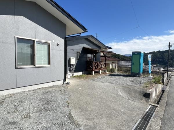 【リフォーム完成・駐車場】ウッドデッキは塗装し直し、庇の波板も交換しました。南側の駐車・お庭スペースのため、日当たりが良く、ご家族でBBQなども楽しんでいただけそうです。