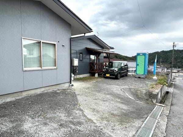 【リフォーム完成・駐車場】ウッドデッキは塗装し直し、庇の波板も交換しました。南側の駐車・お庭スペースのため、日当たりが良く、ご家族でBBQなども楽しんでいただけそうです。