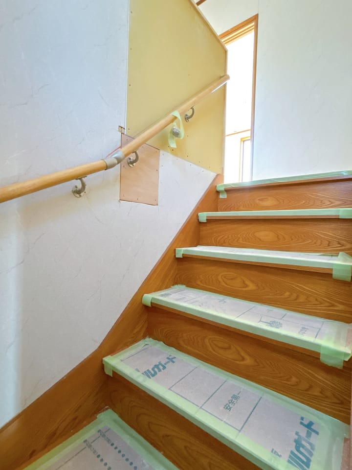 【階段】壁のクロスを張替え、足元はクリーニングとワックスがけを行います。壁に手すり、踏板に滑り止めを新設しますので、お子さまや高齢の方でも上り下りがしやすくなります。