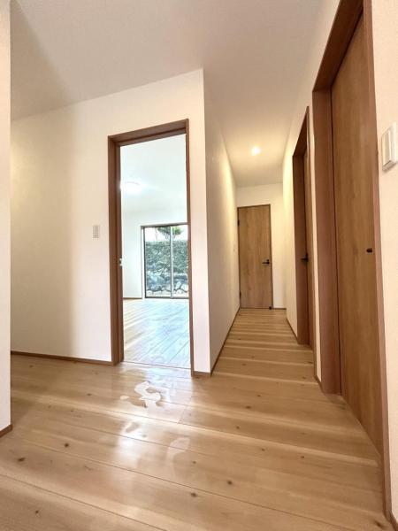 【リフォーム中・廊下】玄関ホールからの視点です。左に曲がるとリビング、画面左手の入り口は8帖の洋室、正面奥にはトイレや洗面脱衣場へ続く扉です。その手前には、7帖洋室がございます。