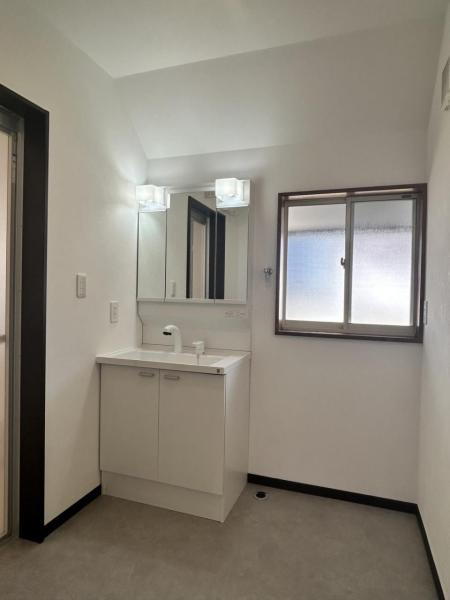 【リフォーム完成 洗面脱衣場】洗面化粧台は三面鏡タイプを採用。床はクッションフロア仕上げで、水気の多い浴室周りでも、きれいにお使いいただけます。