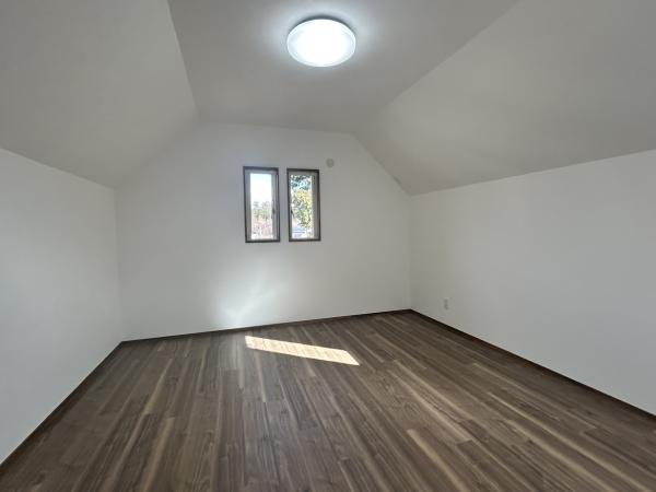 【約9帖洋室 別アングル リフォーム完成】天井・壁クロスの張替え、床はフロアタイルを重ね張り。照明器具はLED照明へと交換いたします。クロスは白基調で明るい印象です。