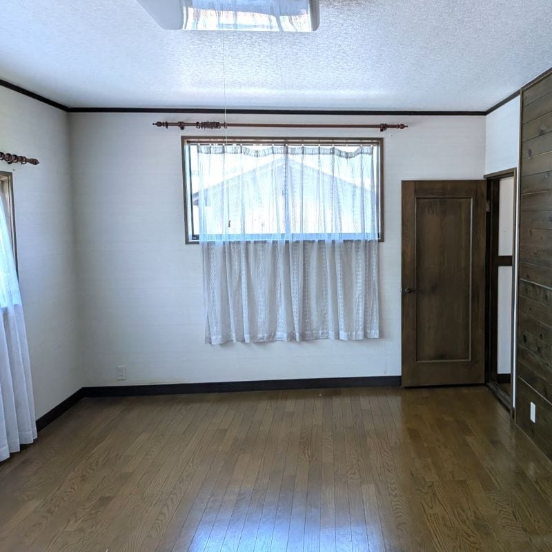 12.5帖の広々とした2階洋室。落ち着いた木目の壁と自然光が心地よい空間です。