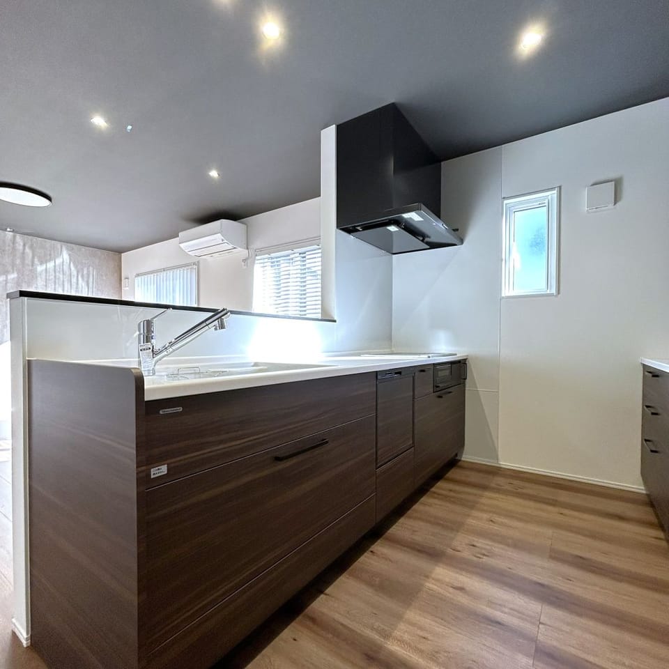 木目柄の扉面材がナチュラルなシステムキッチン。人造大理石ワークトップとIHコンロでお掃除もしやすく衛生的です。