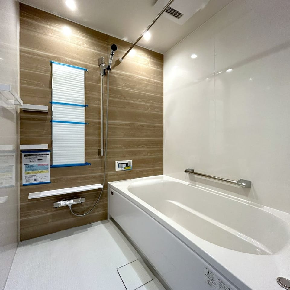 柔らかなグレージュのパネルが癒しの時間を演出する浴室。汚れが入りにくい磁器タイルの床でお掃除も簡単です。