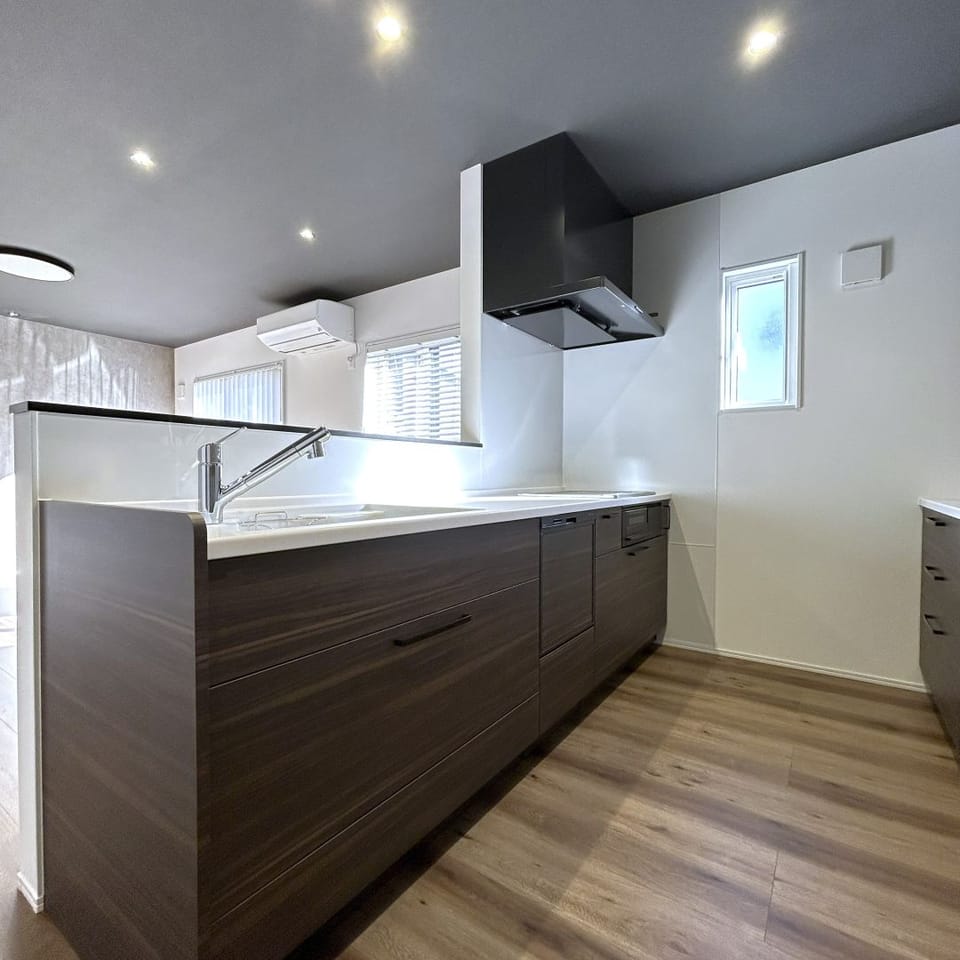 木目柄の扉面材がナチュラルなシステムキッチン。人造大理石ワークトップとIHコンロでお掃除もしやすく衛生的です。