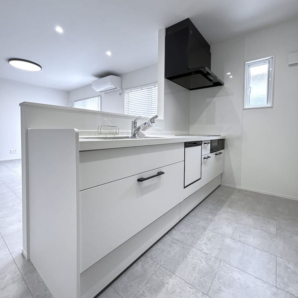 バランスの良い白が映えるシンプルなキッチン。人造大理石ワークトップで清潔感があり、お掃除も楽々です。