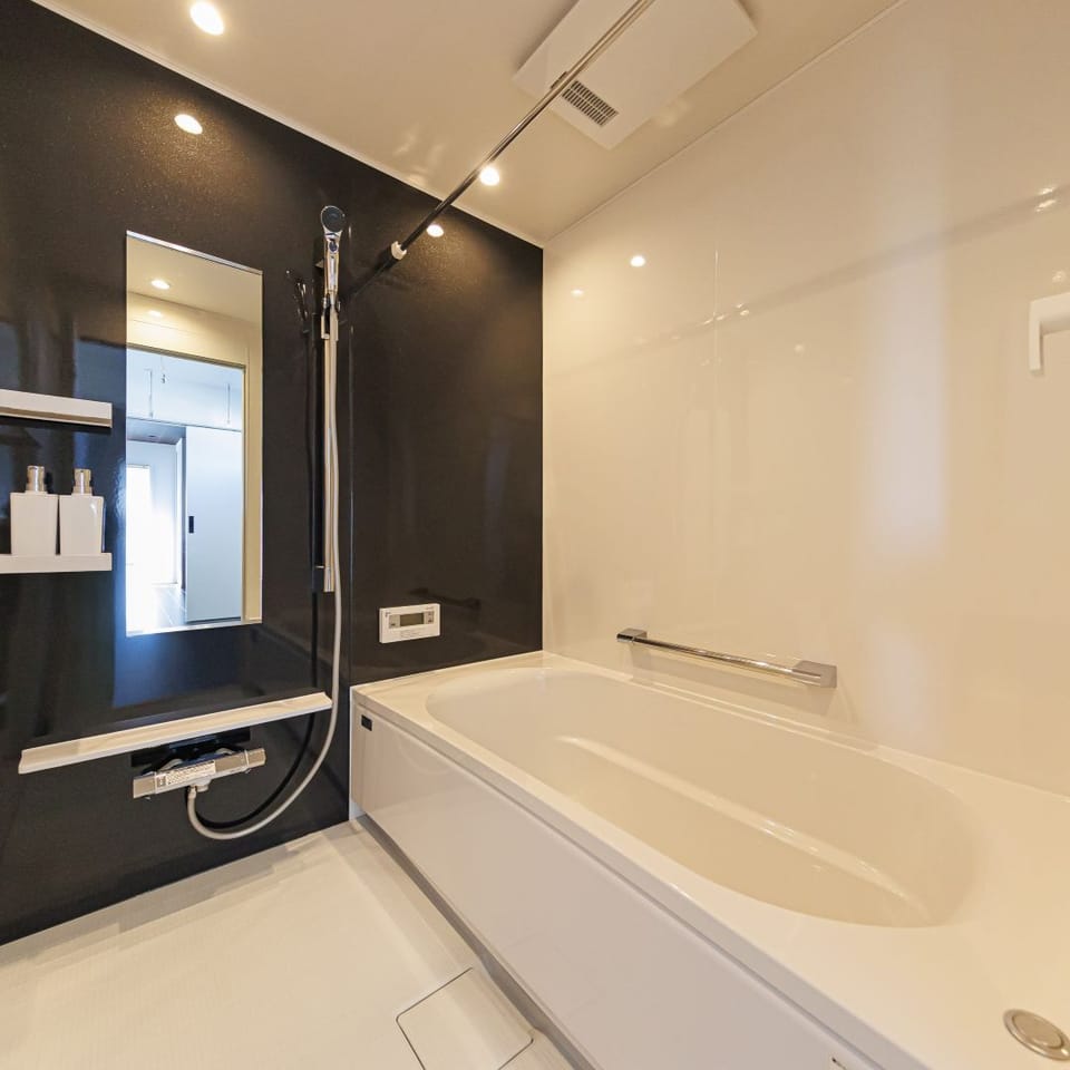ホワイトを基調に、ブラックのパネルがアクセントとなったモダンな浴室。清潔感と高級感を兼ね備えています。