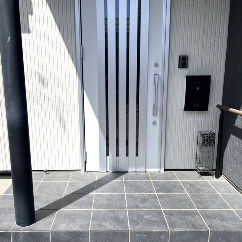 シルバーの玄関扉が外観のポイント。縦ラインの窓からほどよく光が差し込み、玄関ホールが明るい雰囲気に。