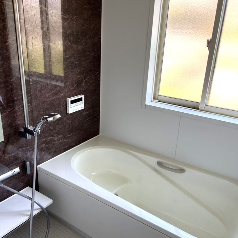 ダークブラウンのアクセントパネルがポイントの高級感のある浴室。落ち着いた空間で一日の疲れを癒せます。