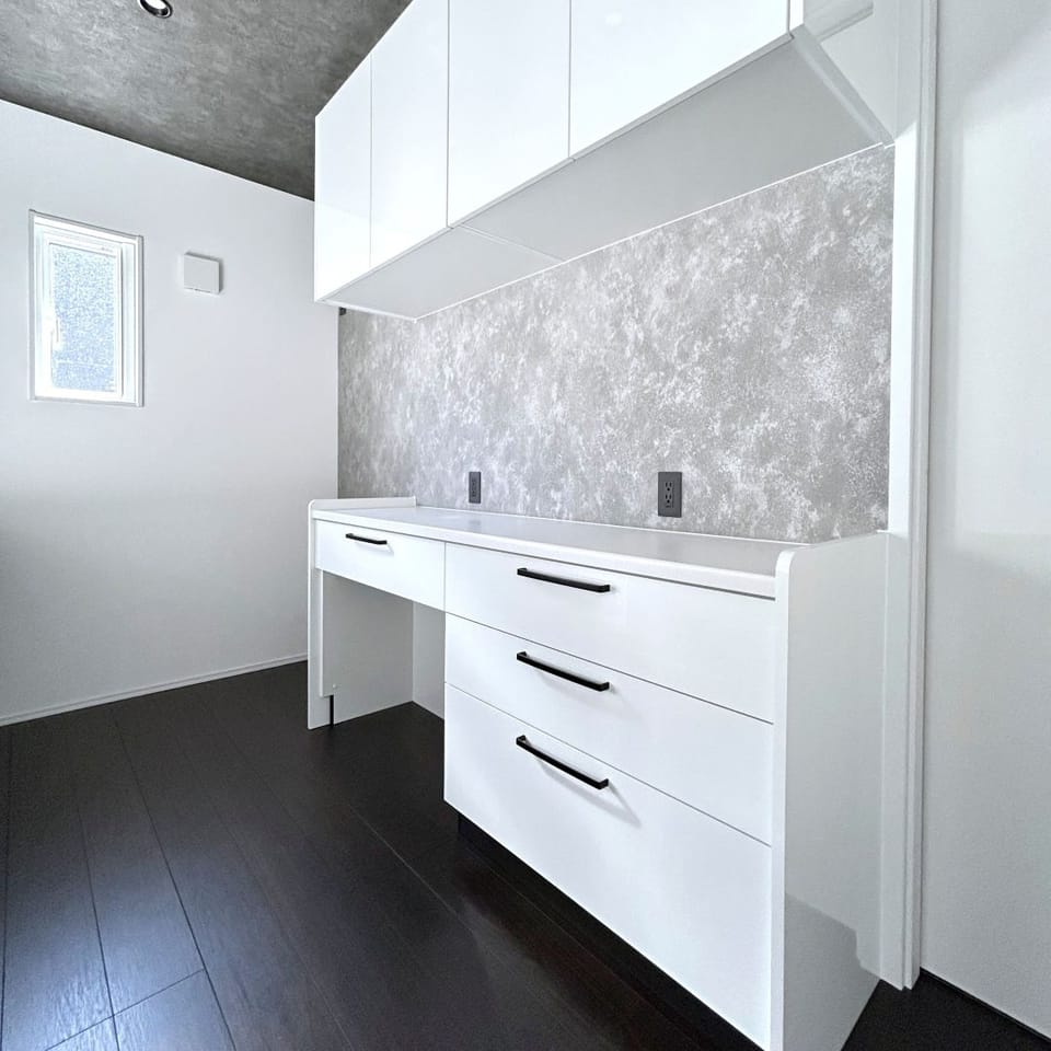 キッチンをダークカラー、カップボードをホワイトでコーディネート。洗練された美しいコントラストを生み出しています。