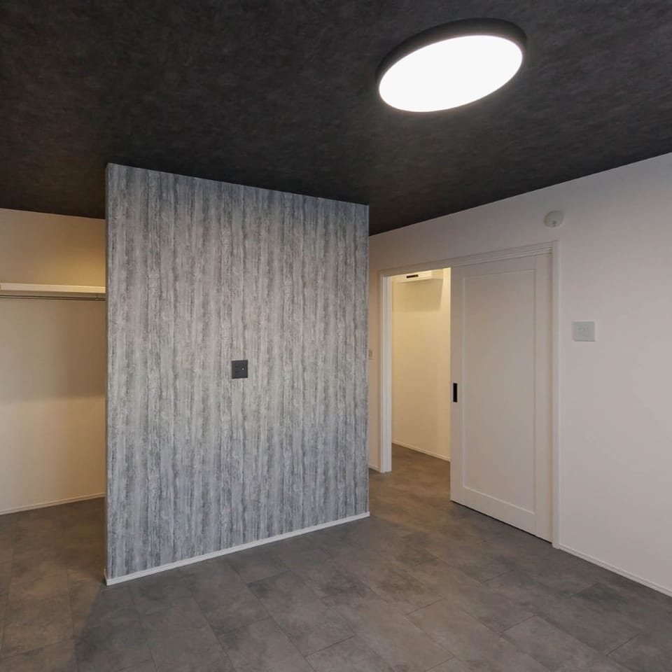 10帖寝室は、モルタル調フローリングとブラックの天井を採用。落ち着きと洗練を感じさせる、モダンな雰囲気に仕上げました。