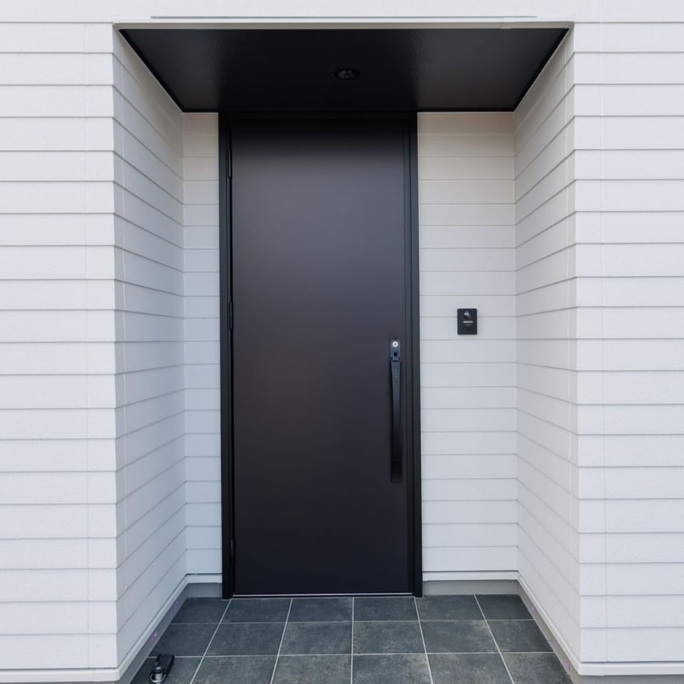 マットブラックの玄関扉を採用し、モノトーンで統一された玄関。タイル張りのアプローチが住まいの品格を演出します。