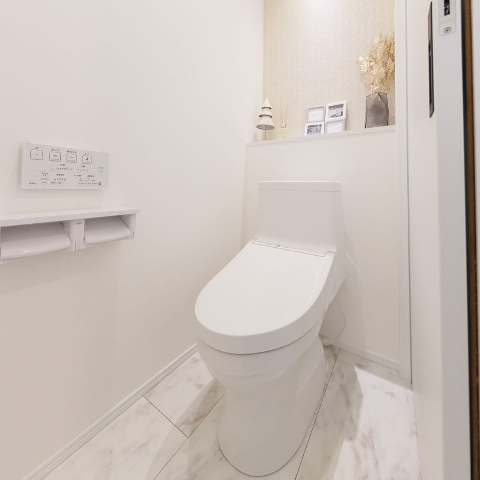 アクセントクロスでデザイン性も兼ね備えた、清潔感あふれる明るいトイレ空間。お手入れ楽々と人気のTOTO製です。