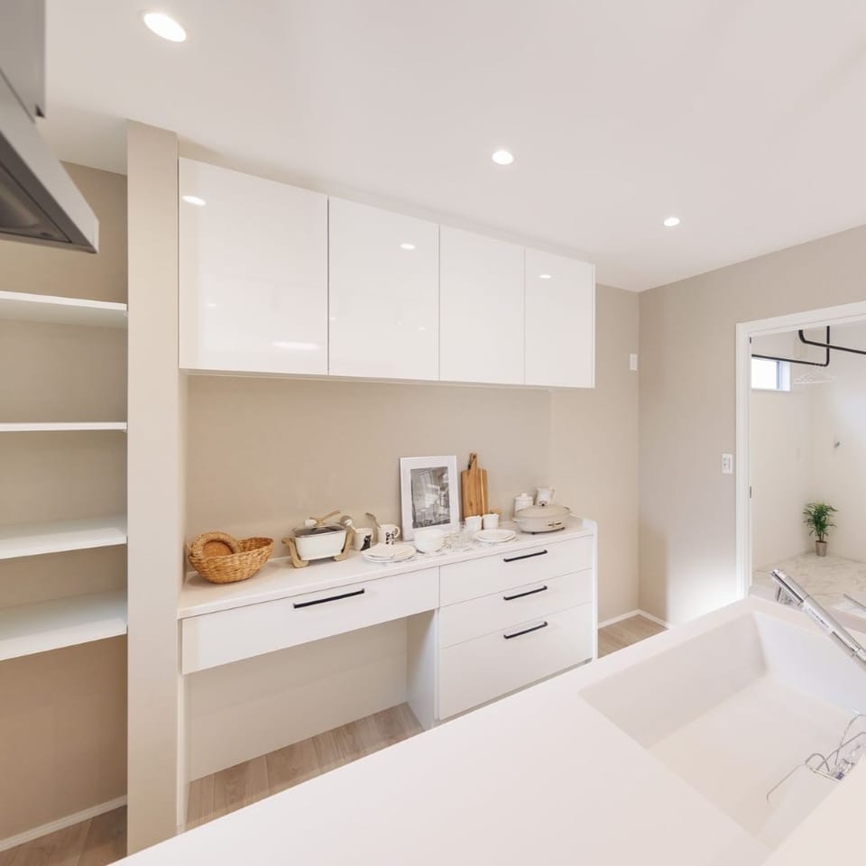 キッチン背面には収納量ばっちりのカップボード付。奥にはパントリー代わりになる可動棚収納も。