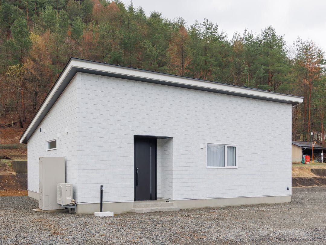 ホワイトの大判タイル柄が柔らかな印象の外観。細い目地と自然なムラ感が、落ち着いたモダンデザインを引き立てます。