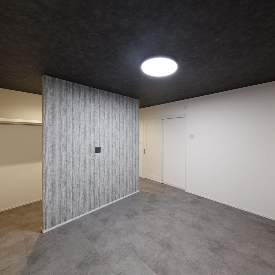 10帖寝室は、モルタル調フローリングとブラックの天井を採用。落ち着きと洗練を感じさせる、モダンな雰囲気に仕上げました。