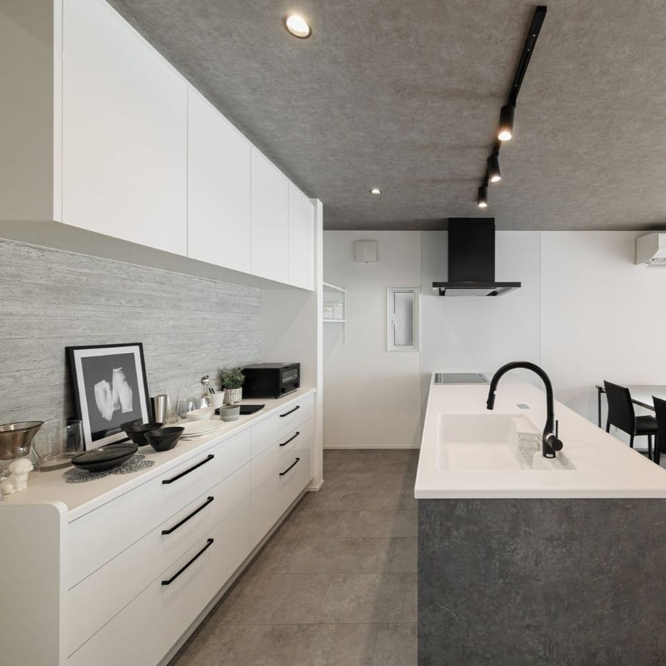 ホワイトで統一したカップボードが、空間に清潔感をプラス。奥にはパントリーとして使える可動棚収納を設けました。