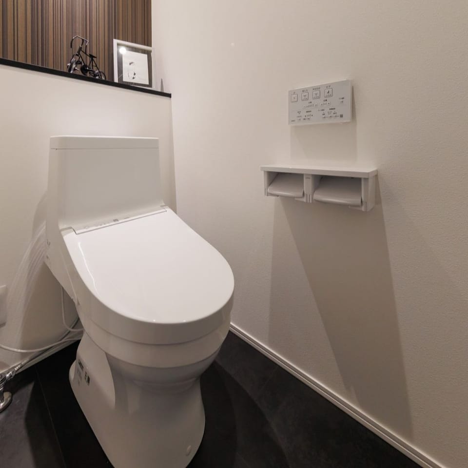 お手入れ簡単なTOTO製トイレを採用。モダンテイストのアクセントクロスが空間を引き締めます。