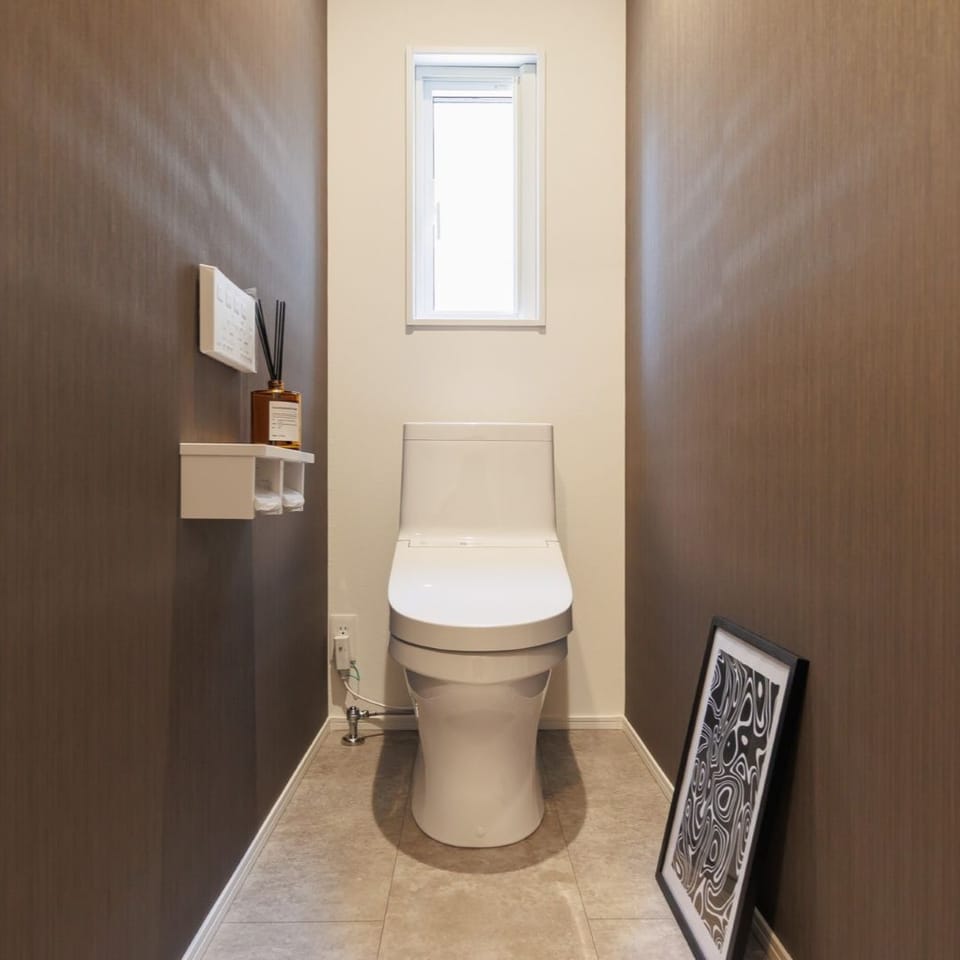 ストライプ調のクロスが印象的なトイレ空間。シンプルな中にもデザイン性をプラスし、上質な雰囲気を演出。