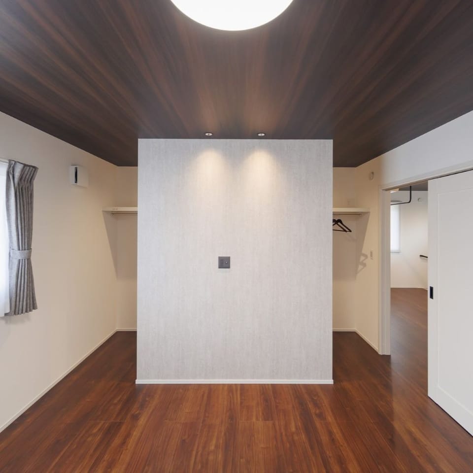 ダークな木目の天井と大理石調のアクセント壁紙が映える寝室。上質でエレガントなコーディネートが、くつろぎの時間にぴったり。