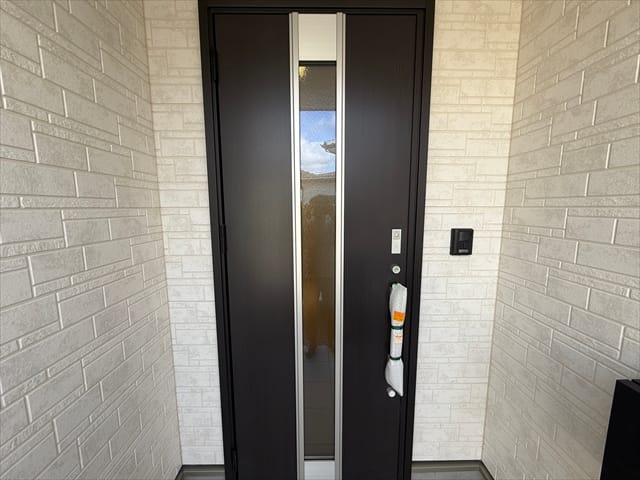 玄関扉は落ち着いたデザインです。白い外壁とマッチしていますね。