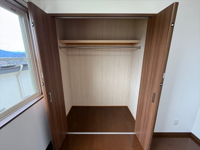 クローゼットの扉を開けると、上部には枕棚、中央には便利なハンガーパイプが設置されています。