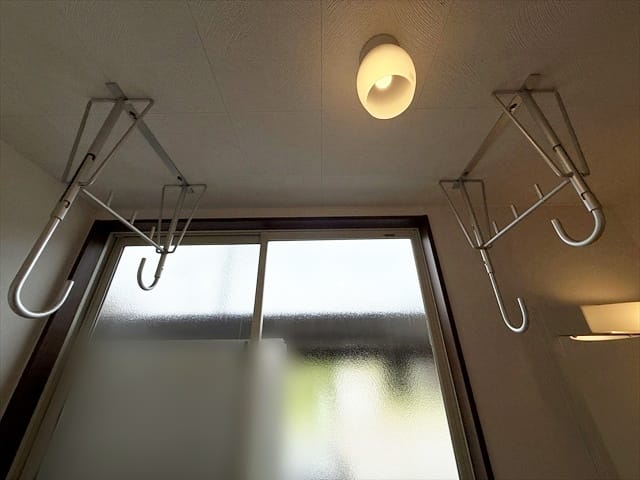 洗濯機置き場の上部には、雨の日や夜間の室内干しに重宝する物干し金物が設置されています。
