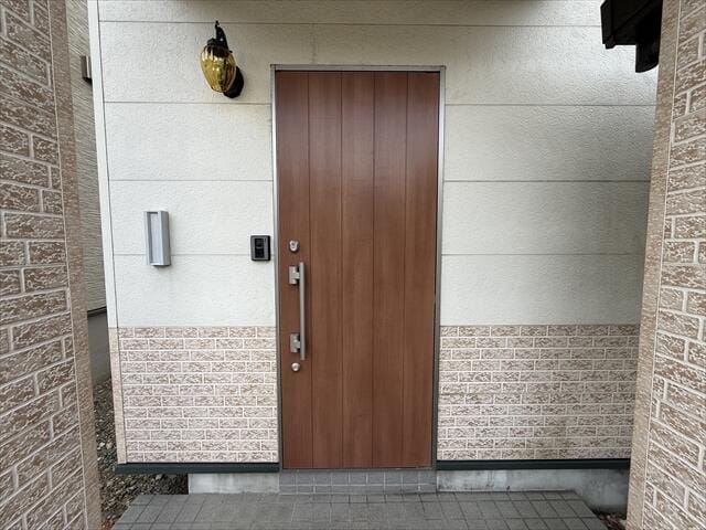 玄関まわりは落ち着いたレンガ調のアクセント壁。照明やインター