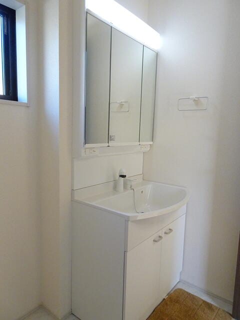 シンプルで機能的な洗面台。3面鏡の鏡は大きくてご家族ならんで