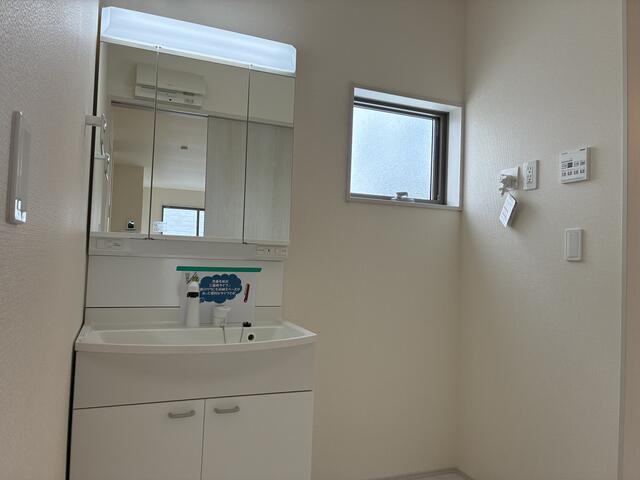 洗面台はシンプルなデザイン。鏡の後ろは収納スペース、ハンドシ