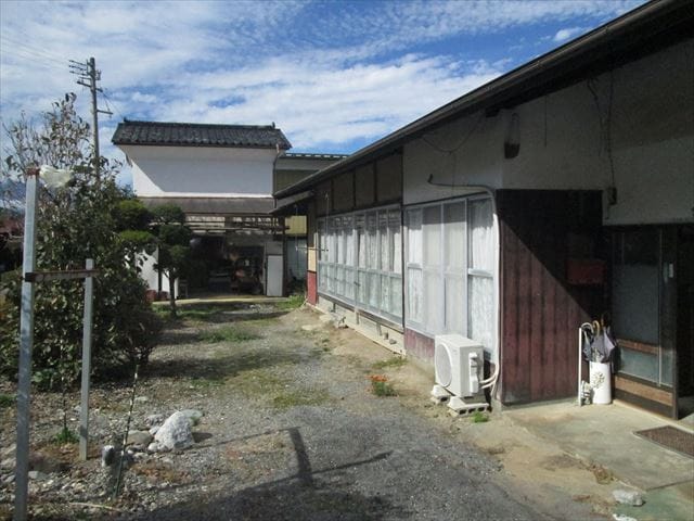 東側より母屋とコンクリートブロック造の倉庫